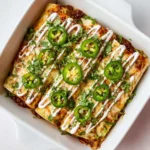 Plate of shredded beef enchiladas topped with cheese and cilantro.