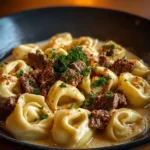 Creamy cheesesteak tortellini in rich provolone sauce served in a bowl