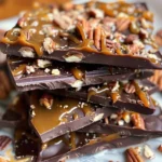 Homemade chocolate caramel bark topped with nuts and sea salt.