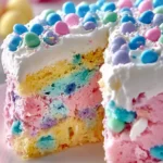 Delicious Easter Poke Cake adorned with colorful sprinkles and pastel frosting.