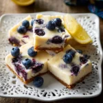 Delicious Blueberry Cheesecake Bars topped with fresh blueberries and a creamy layer.