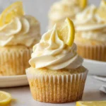 Freshly baked lemon cupcakes topped with creamy frosting and lemon zest