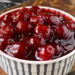 Homemade cherry pie filling in a bowl with fresh cherries